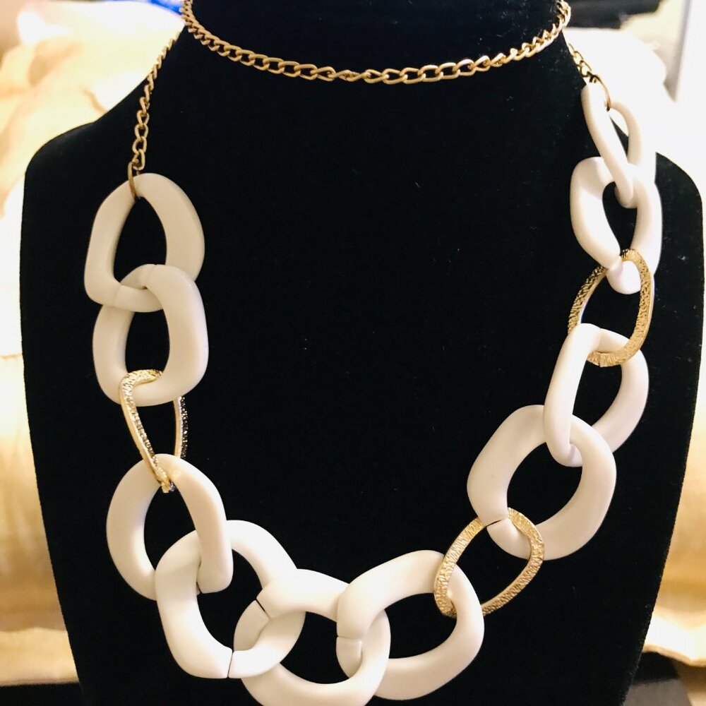 WHITE AND GOLDTONE RINGS SUSPENDED BY A GOLDTONE CHAIN COLLAR NECKLACE
